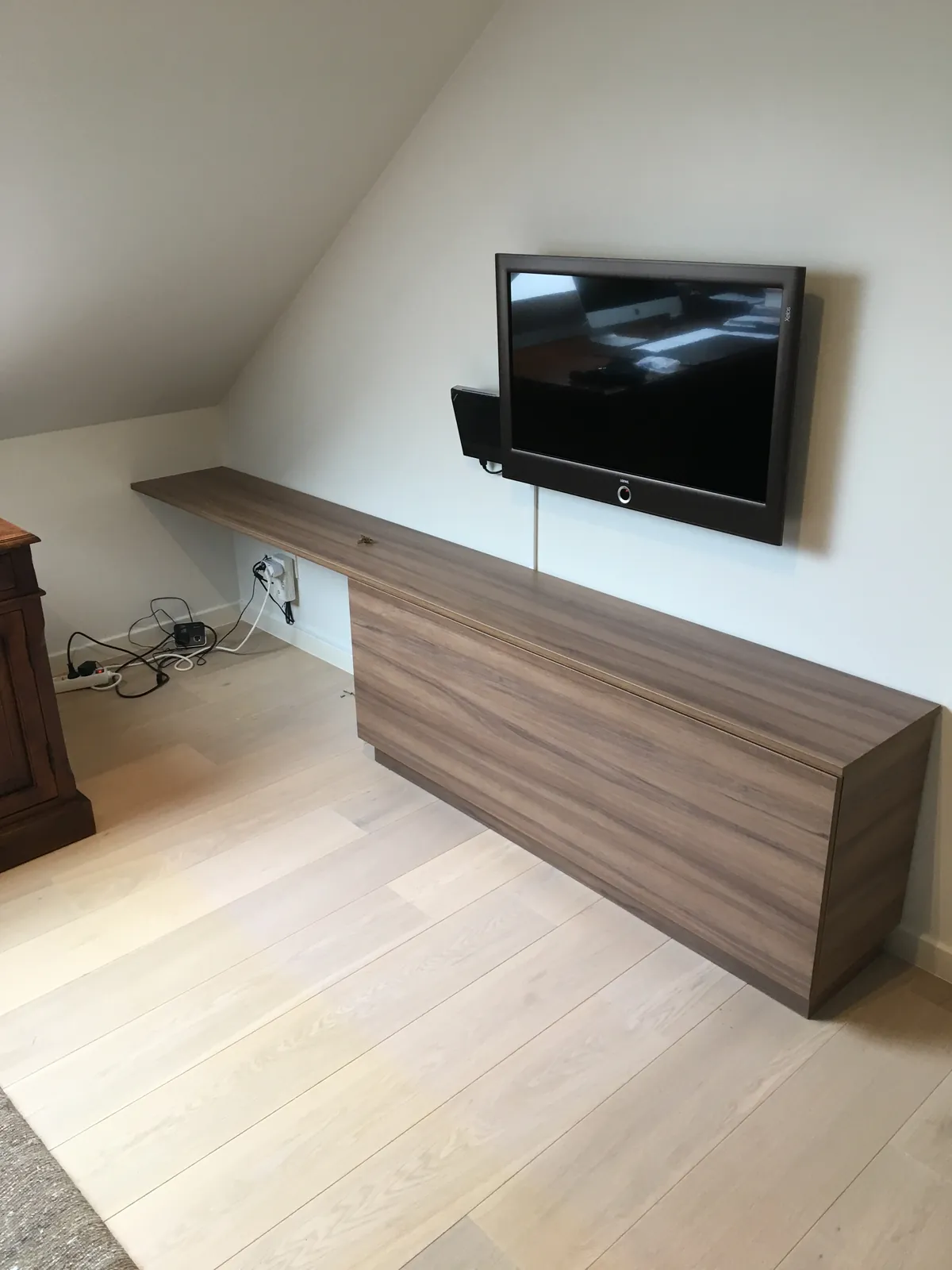 Zwevend tv-meubel in houtdecor op een zolderkamer