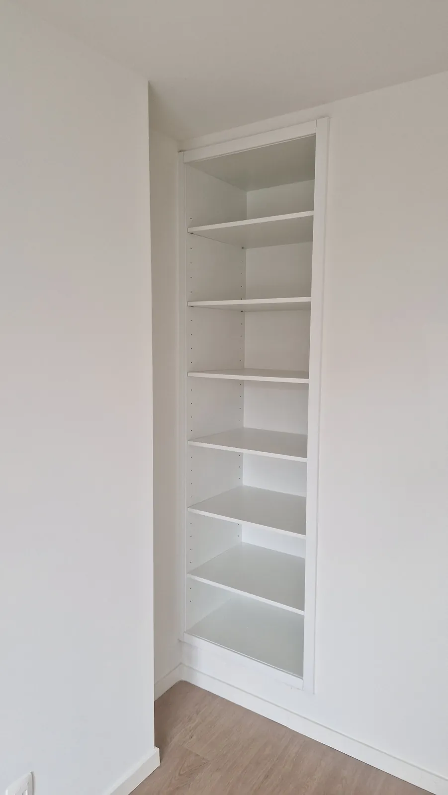 Witte boekenkast op maat in een nis