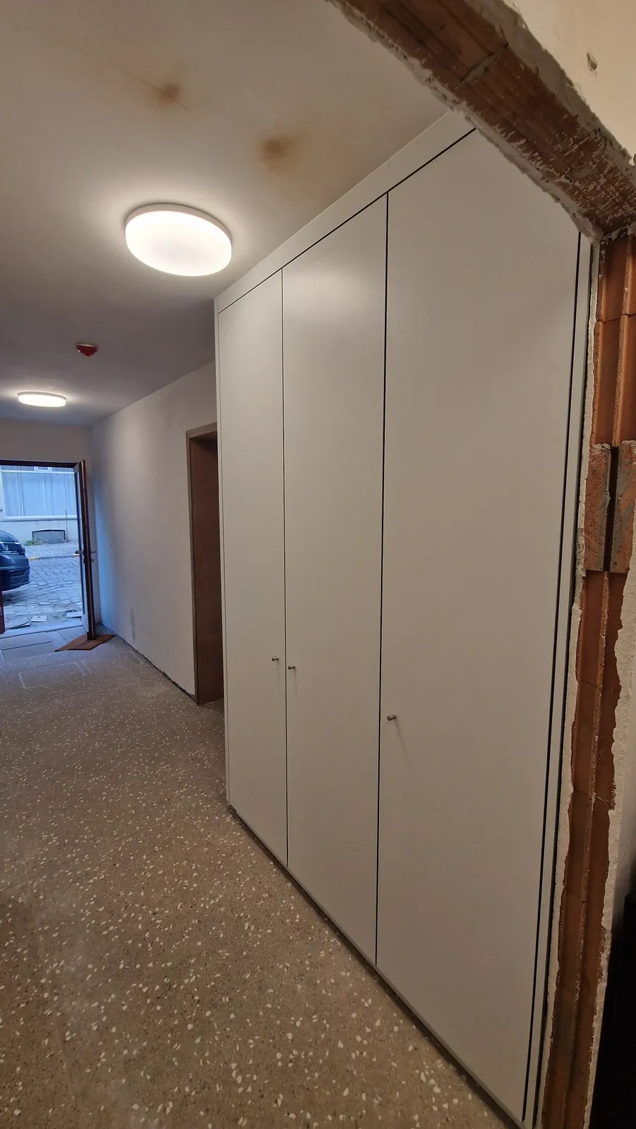 Grijze kastenwand over de lengte van een gang