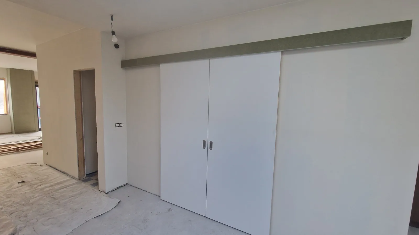Witte schuifdeurkast over de volledige wand