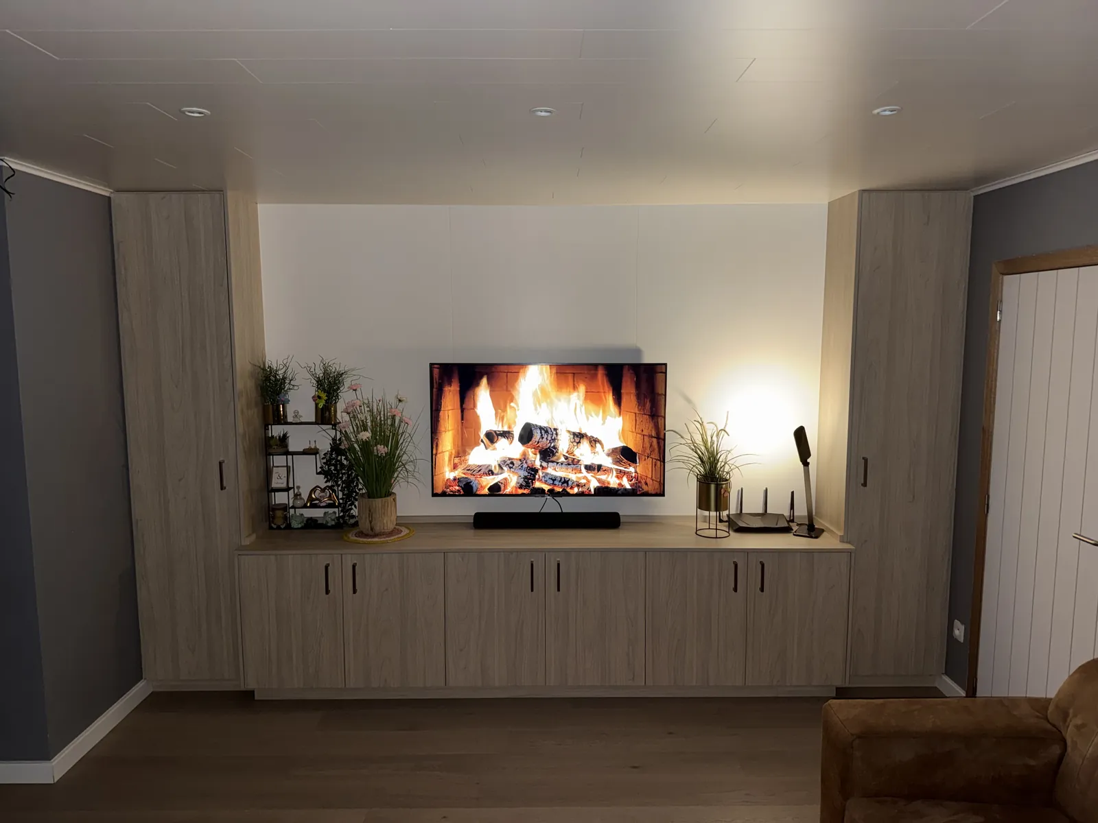 Tv-wand op maat in eikdecor met hoge kolomkasten en lage kasten