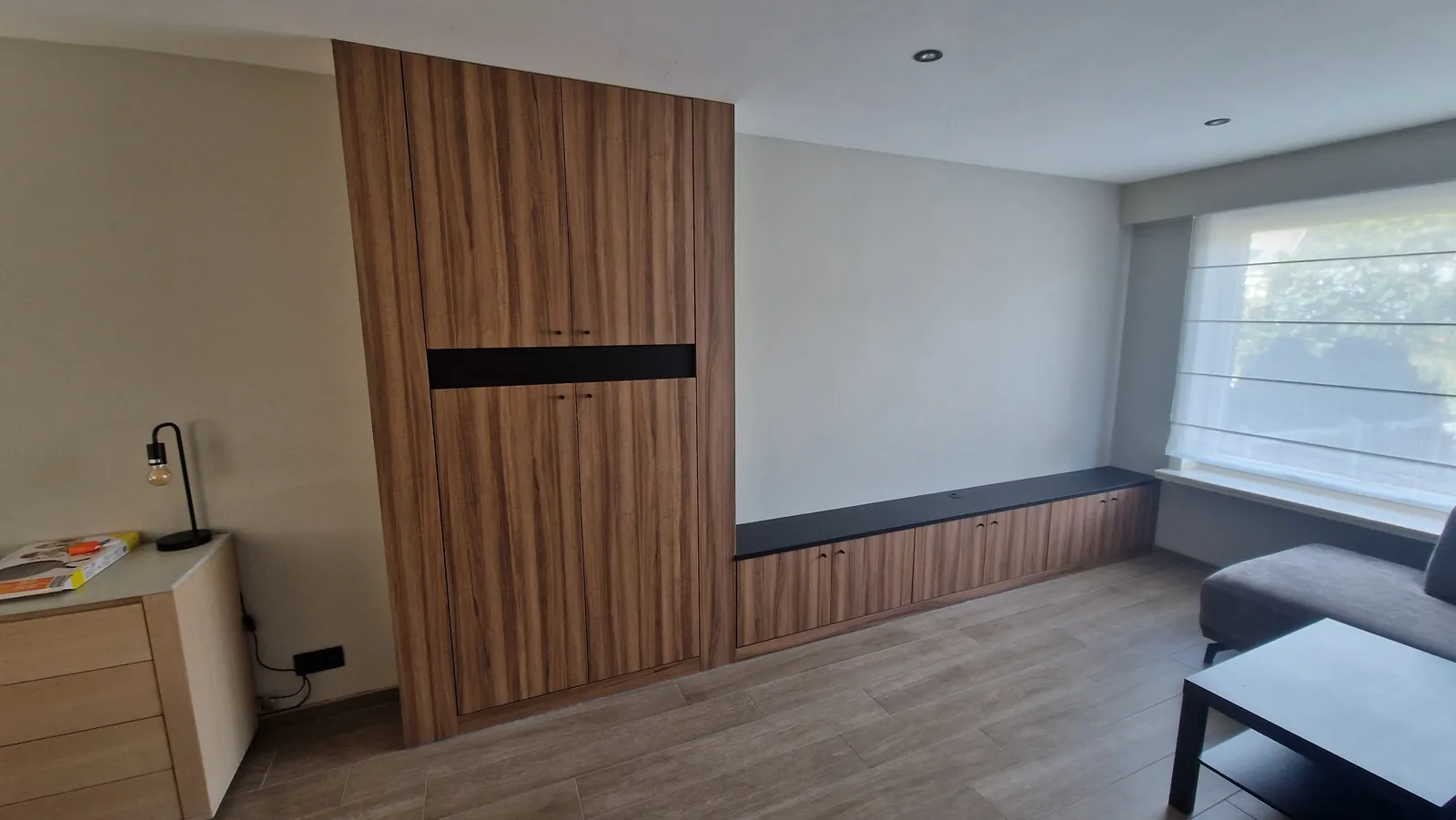 Wandkast in notelaardecor met zwarte accentstrook en zitbank