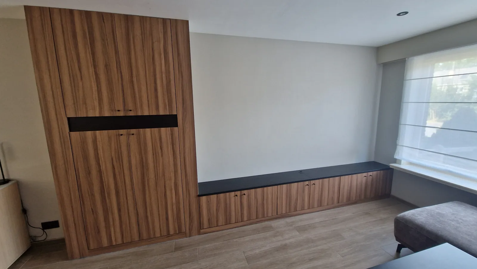 Wandkast en zitbank in notelaardecor onder het raam