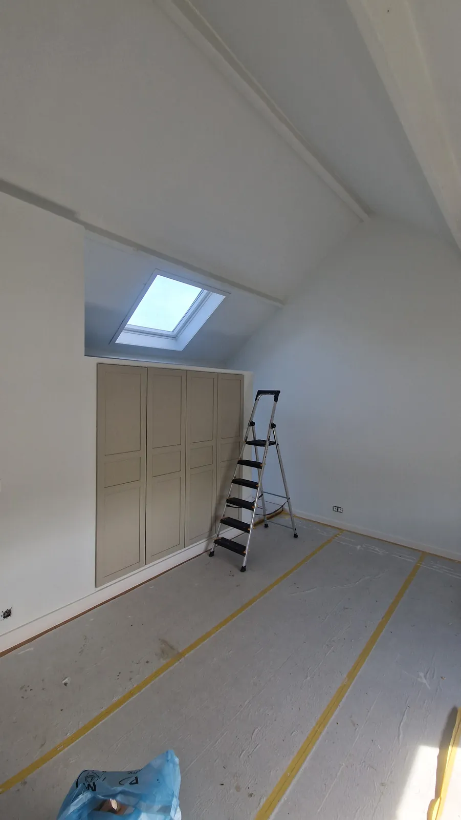 Kasten met paneeldeuren in de knieschotten van een zolderkamer