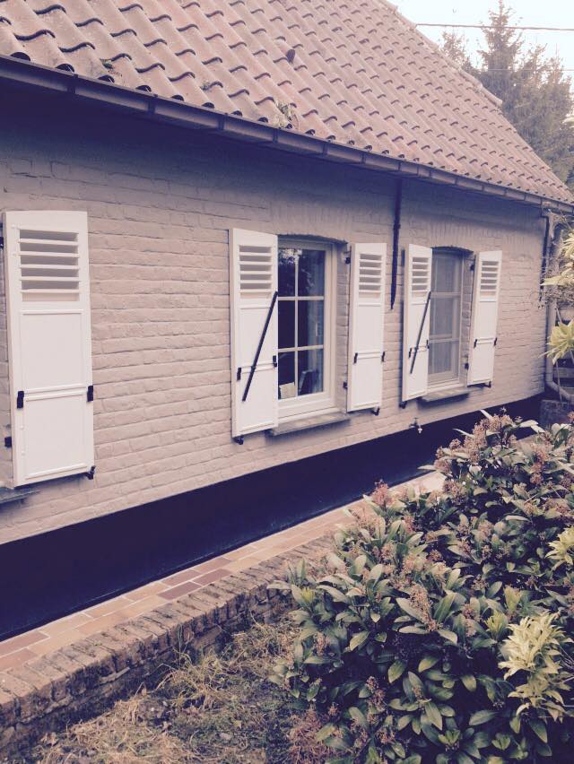 Woning met witte houten ramen en luiken