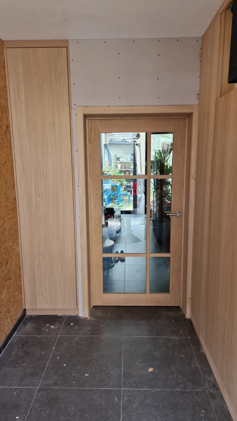 Binnendeur met glas in een wand met eiken bekleding