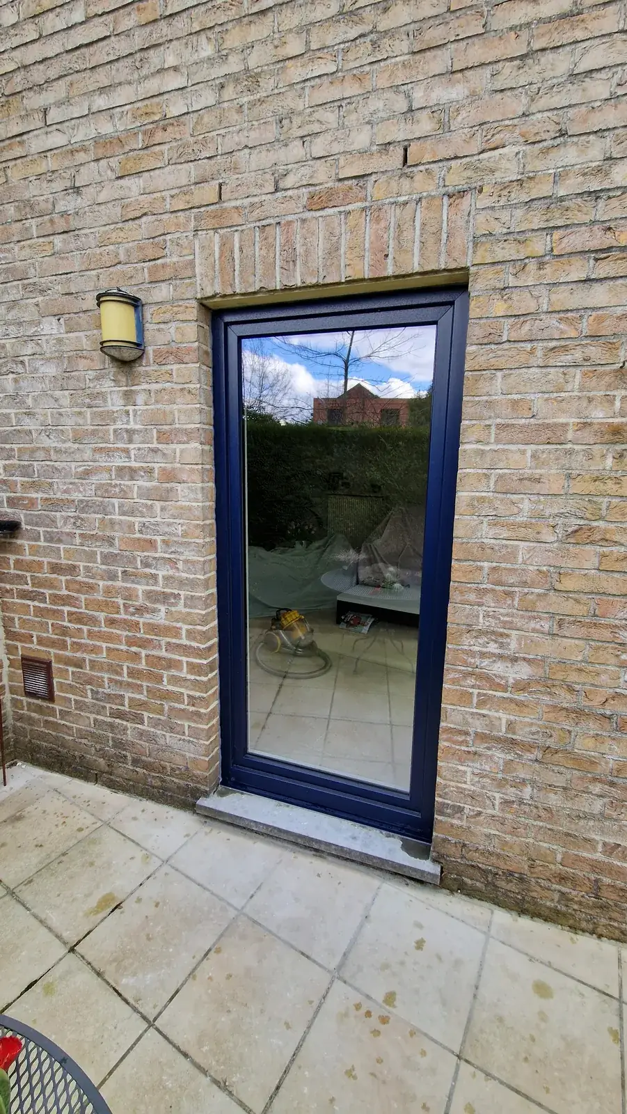 Buitendeur met donkerblauw kader naar het terras