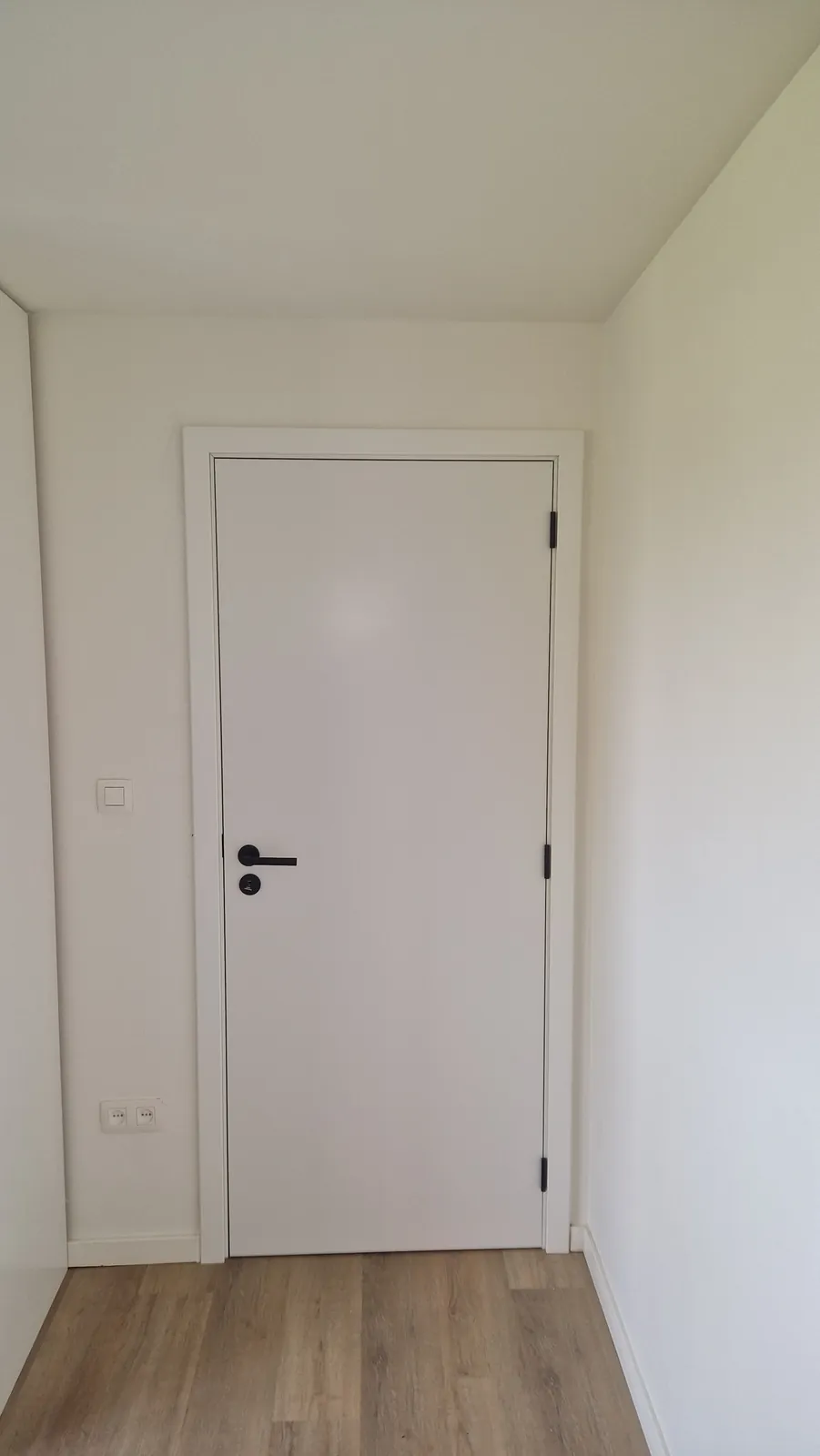 Witte binnendeur in een afgewerkte kamer