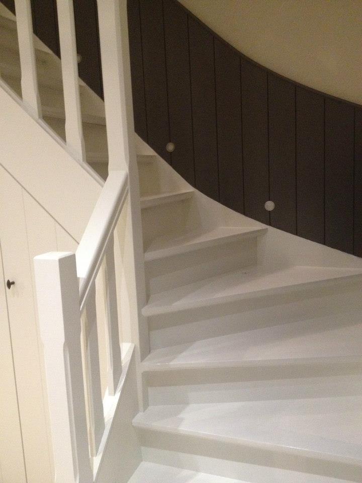 Witte trap met houten leuning