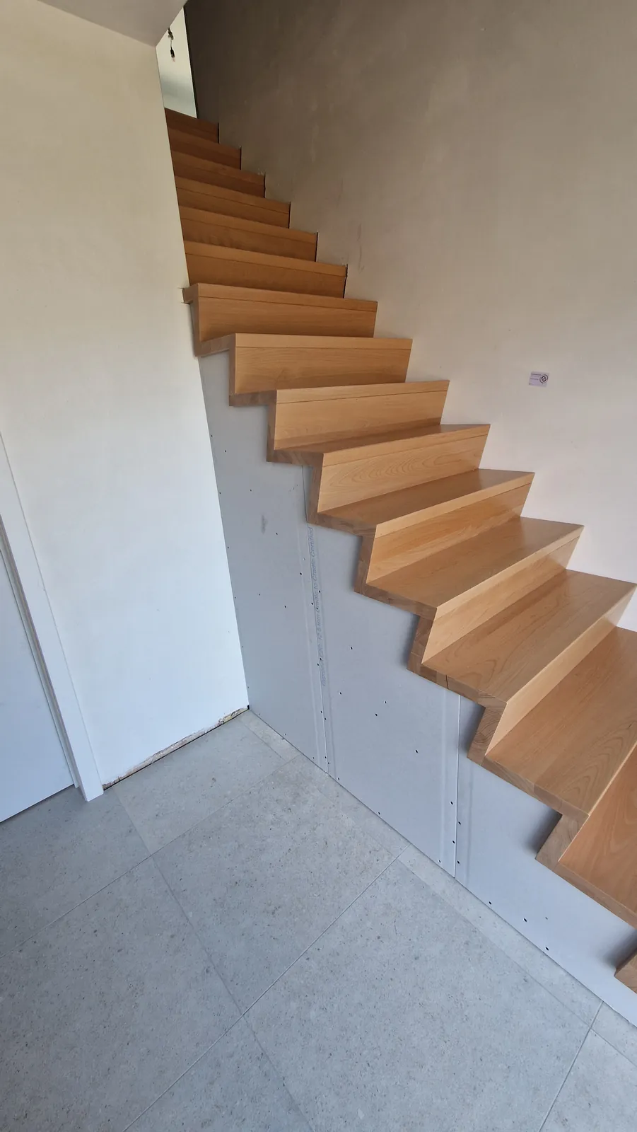 Zwevende trap in eik langs de wand